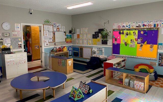 Bright and welcoming toddler classroom with age-appropriate learning stations, play areas, and educational activities